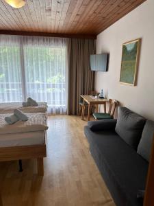 ein Wohnzimmer mit einem Sofa und einem Tisch in der Unterkunft Gasthof Stern in Vandans