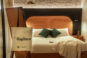 łóżko z czarnym zagłówkiem i zielonymi poduszkami w obiekcie Officina Daplace w Rzymie