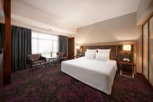 河內的住宿－河內鉑爾曼酒店，配有一张床和一张书桌的酒店客房