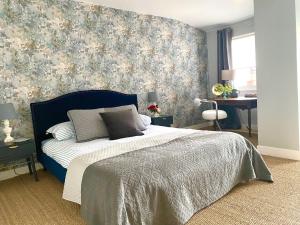 1 dormitorio con 1 cama con cabecero azul en Château de Gouyas en Montagrier