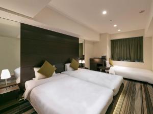 a hotel room with two beds and a window at Hotel Brighton City Osaka Kitahama in Osaka