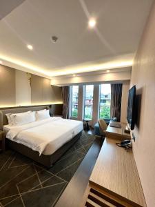 um quarto de hotel com uma cama e uma televisão em Wah Fu Hotel em Ho Chi Minh