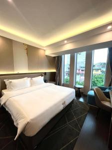 a hotel room with a large bed and windows at Wah Fu Hotel in Ho Chi Minh City