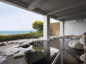een zwembad met water voor een gebouw bij Grand Mercure Beppu Bay Resort & Spa in Beppu