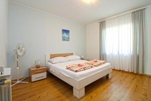 Biała sypialnia z łóżkiem i wentylatorem w obiekcie Apartments Pjescana Uvala 606 w mieście Pješčana Uvala