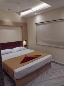 a bedroom with a bed with a red napkin on it at HOTEL SKYKING in Gauripur