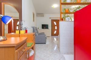 Studio Apartment Oliva في بولا: مطبخ وغرفة معيشة بجدار احمر
