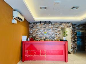 a red counter in a room with a stone wall at Swing & Pillows -MyHome Hotel Wangsa Maju in Kuala Lumpur