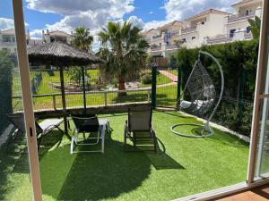 un patio con 2 sillas y un columpio en Casa Leonardo Luxury Esury, en Ayamonte