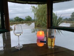 a candle and two glasses on a table with a view of a river at Owls Retreat, Meadowview House in Stoke on Trent