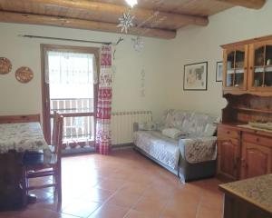 a living room with a bed and a window at Soggiorno Vacanze Stella Alpina in Temù