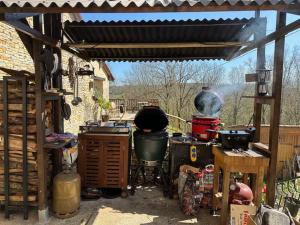 an outdoor kitchen with a grill and a stove at Domaine Lapin Qui Rit , chambre Céline in Saint-Jean-de-Côle