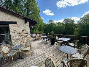 a deck with tables and chairs and tables and chairs at Domaine Lapin Qui Rit , chambre Céline in Saint-Jean-de-Côle