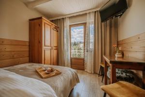 a bedroom with a bed and a desk and a window at Gościna u Maryny & SPA pod Tatrami in Poronin
