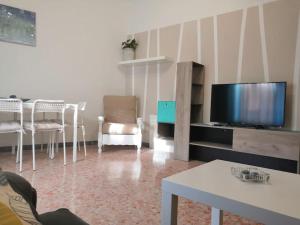 a living room with a tv and a table and chairs at Lo Scorcio sul porto in Porto Santo Stefano