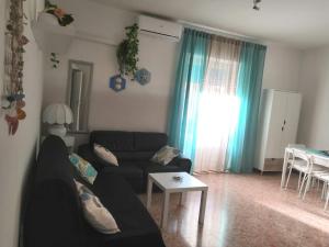 a living room with a black couch and a table at Lo Scorcio sul porto in Porto Santo Stefano