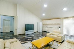 バクーにあるPolaris Penthouseのソファとテーブルとテレビのあるリビングルーム