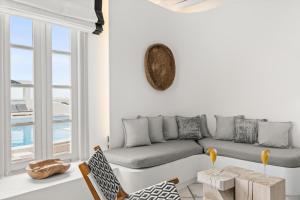 a white living room with a couch and a table at Mr and Mrs White Paros in Naousa