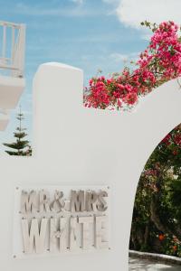 Um sinal que diz Sr. e Sra. White com flores. em Mr and Mrs White Paros em Naousa