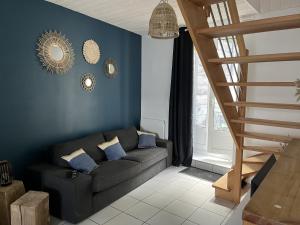 salon z kanapą i niebieską ścianą w obiekcie Gîte à Saint-Marcan-Baie du Mont-Saint-Michel w mieście Saint-Marcan
