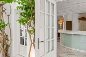 uma porta que leva a uma sala com uma árvore em Mr and Mrs White Paros em Naousa