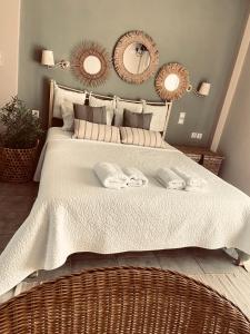 a bedroom with a large bed with two towels on it at Las plantas-studios-apartments-Corfu in Dassia