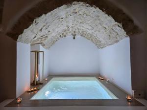 a large swimming pool in a room with a ceiling at Muribel Maison in Ceglie Messapica