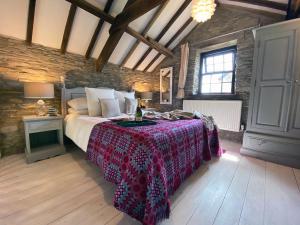 1 dormitorio con 1 cama en una habitación con una pared de ladrillo en Granary Cottage St Clears, en St Clears