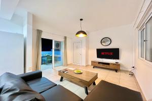 a living room with a couch and a tv at Villa White Star - 100m from Serena Beach in Protaras