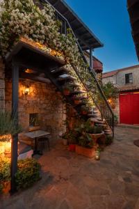 a patio with a staircase and a table with plants at Alacati Eski Ev Hotel in Alacati