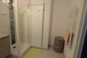 a bathroom with a shower and a trash can at Au gré des Vagues, vue mer, wifi, piscine chauffée in Concarneau +20 photos