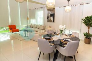 uma sala de jantar e sala de estar com mesa e cadeiras em Bloomfields - Private Townhouse At Reem Island em Abu Dhabi