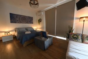 een slaapkamer met een bed en een bank bij Terra Sinus Beautiful Suite in Terrasini