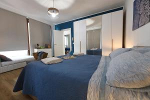 een slaapkamer met een blauw bed en een bank bij Terra Sinus Beautiful Suite in Terrasini