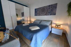 een slaapkamer met een bed met een blauwe deken bij Terra Sinus Beautiful Suite in Terrasini