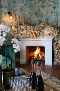 a living room with a fireplace with a fire at Auberge Burgundy Boutique Hotel & Spa in Hermanus