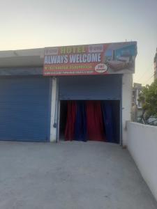 un edificio con un garaje con un cartel. en OYO HOME 80891 Hotel Always Welcome en Jewar