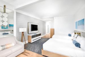 - une chambre blanche avec un lit et un canapé dans l'établissement The Ritz-Carlton, Fort Lauderdale, à Fort Lauderdale