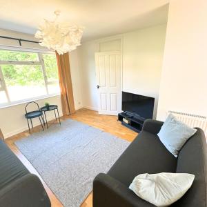 a living room with a couch and a chandelier at Newly refurbished 2 bed in Thame in Thame