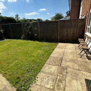 a yard with two benches and a fence at Newly refurbished 2 bed in Thame in Thame