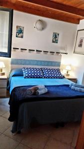 sypialnia z dużym łóżkiem z niebieską pościelą w obiekcie SU BISU, Costa Rei, Ferienhaus, sea view, 500m from the beach w mieście Costa Rei
