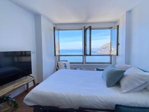 een slaapkamer met een groot bed en een groot raam bij Ribadomar Caion in A Coruña