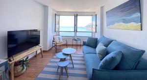 Ribadomar Caion في لا كورونيا: غرفة معيشة مع أريكة زرقاء وتلفزيون بشاشة مسطحة