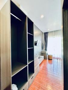 um quarto com um grande armário preto e piso em madeira em Kep Sea View Hotel & Sky Bar em Kep