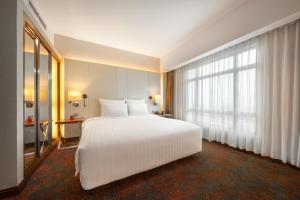 河內的住宿－河內鉑爾曼酒店，卧室设有白色的床和大窗户