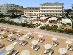 una vista aerea di un resort con sedie e ombrelloni di Hotel Aurora a Lido di Jesolo