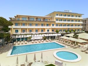 a hotel with a pool and chairs and umbrellas at Hotel Aurora in Lido di Jesolo
