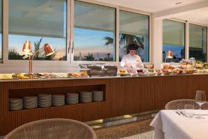 a chef preparing food at a buffet in a restaurant at Hotel Aurora in Lido di Jesolo +149 photos
