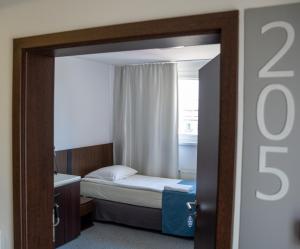 Habitación pequeña con cama y ventana en Aparthotel Strefa Budget en Tychy