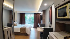 バンコクにあるAspira Suites Sukhumvit 20のベッドとテレビが備わるホテルルームです。